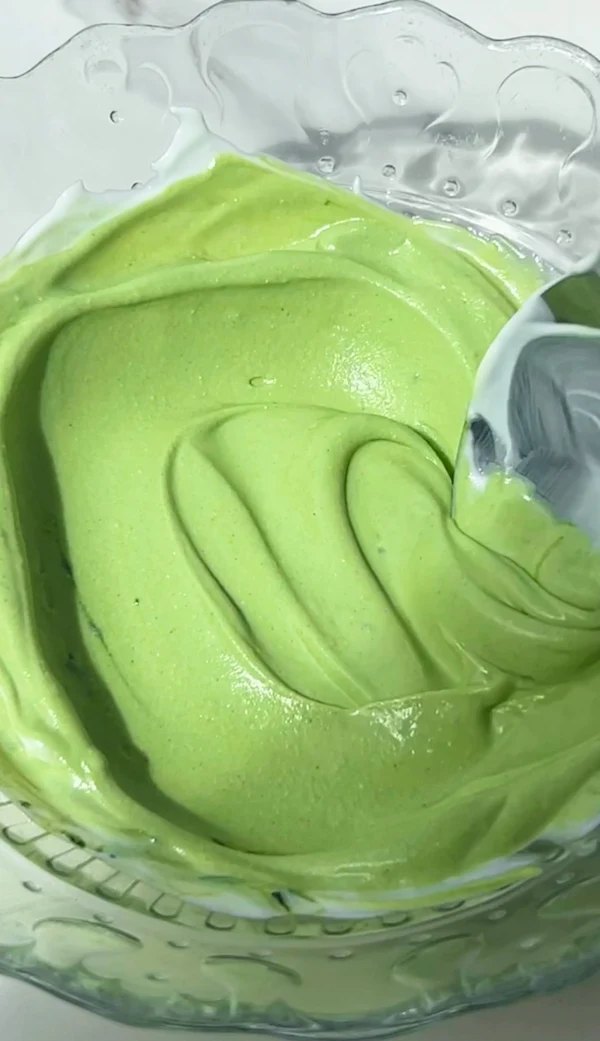 Smooth matcha cheesecake yogurt filling blended in a glass bowl