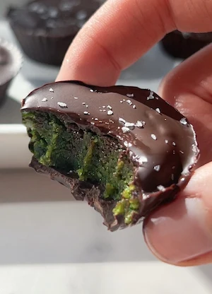 No bake matcha chocolate cups topped with flaky sea salt on a white marble surface